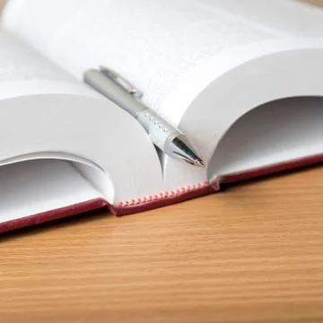 Open book with pen Stock Photos