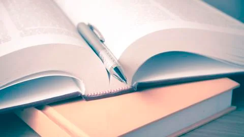 Open book with pen Stock Photos