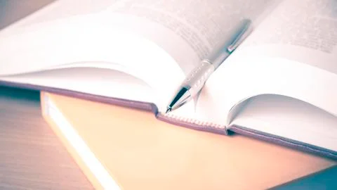 Open book with pen Stock Photos