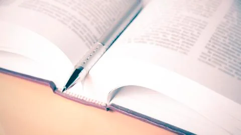 Open book with pen Stock Photos