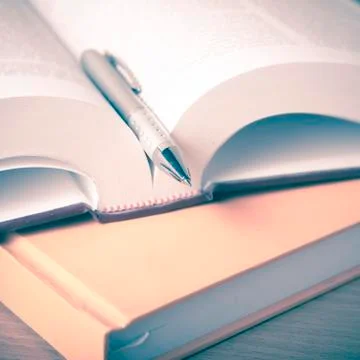 Open book with pen Stock Photos