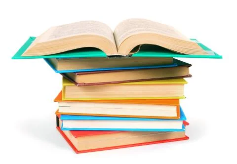 The open book on a pile of multi-coloured books. 스톡 사진