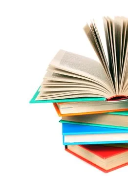 The open book on a pile of multi-coloured books. 스톡 사진