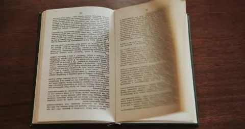 An open book placed on the table, by the wind blowing until the page flipped  Stock Footage 147276711