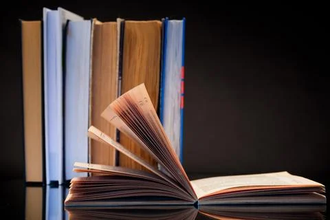 Open book for reading and a stack of books Stock Photos