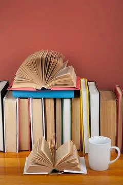 Open book, red cup hardback colorful books on wooden table. Back to school... Foto stock
