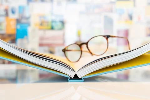 Open book with soft blurred reading glasses Stock Photos