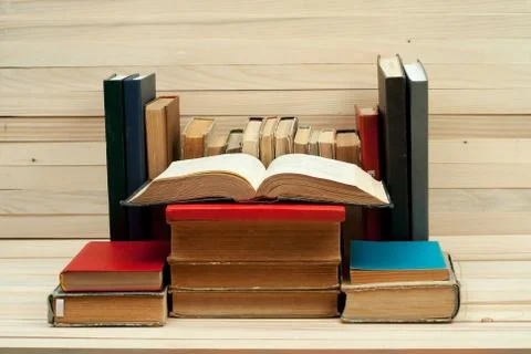 Open book, stack of hardback books on wooden table.  Back to school. Copy space Foto stock