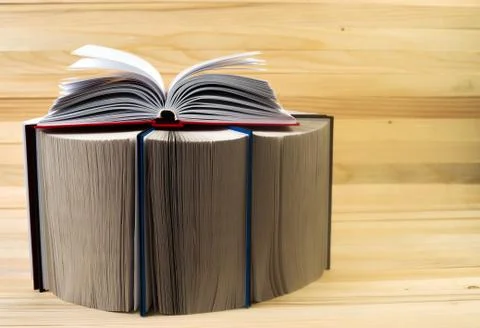 Open book, stack of hardback books on wooden table. Back to school. Copy space Stock Photos