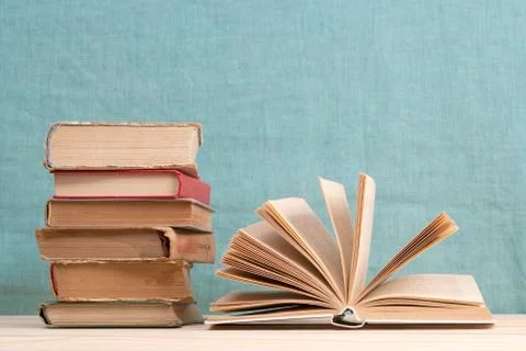 Open book, stack of hardback books on wooden table. Back to school. Copy space Stock Photos