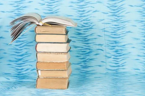Open book, stack of hardback books on wooden table Stock Photos