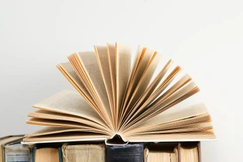 Open book, stack of hardback books on wooden table. Back to school. Copy spac Stock Photos