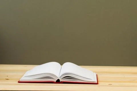 Open book, stack of hardback books on wooden table Stock Photos