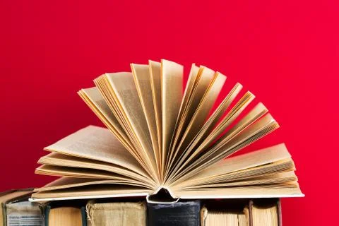 Open book, stack of hardback books on wooden table Stock Photos