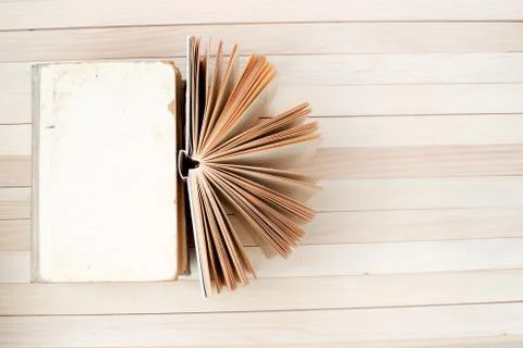 Open book, stack of hardback books on wooden table Stock Photos