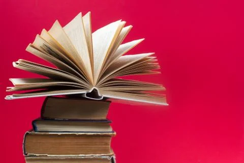 Open book, stack of hardback books on wooden table Stock Photos