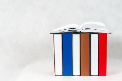 Open book, stack of hardback books on wooden table Stock Photos