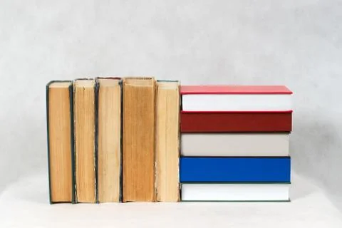 Open book, stack of hardback books on table Stock Photos