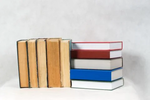 Open book, stack of hardback books on table Stock Photos