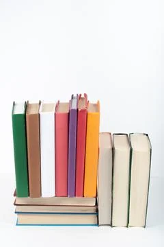 Open book, stack, hardback colorful books on wooden table, white background.. Stock Photos