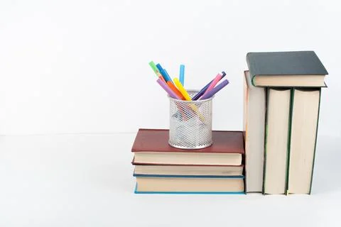 Open book, stack, hardback colorful books on wooden table, white background.. Foto stock