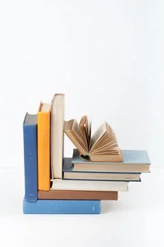 Open book, stack, hardback colorful books on wooden table, white background.. 写真素材