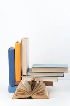 Open book, stack, hardback colorful books on wooden table, white background.. Stock Photos