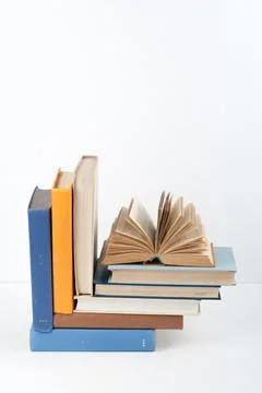 Open book, stack, hardback colorful books on wooden table, white background.. Stock Photos