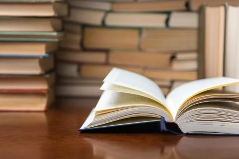 Open book on the table against the background of books Stock Photos