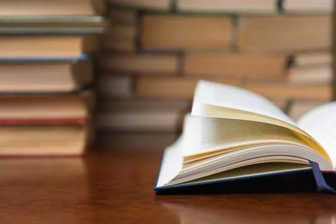 Open book on the table against the background of books Stock Photos