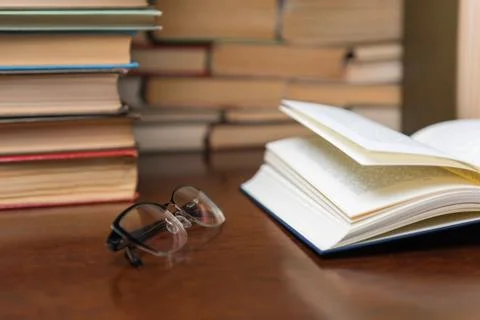 Open book on the table against the background of books Stock Photos