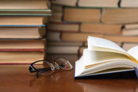 Open book on the table against the background of books Stock Photos