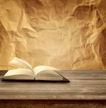Open book on table in front of paper background Stock Photos