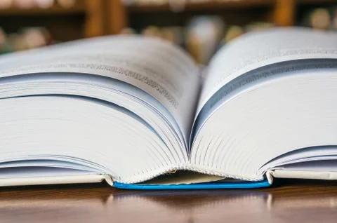 Open book on the table in library Stock Photos