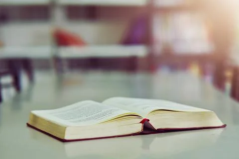 Open book on the table in library Stock Photos