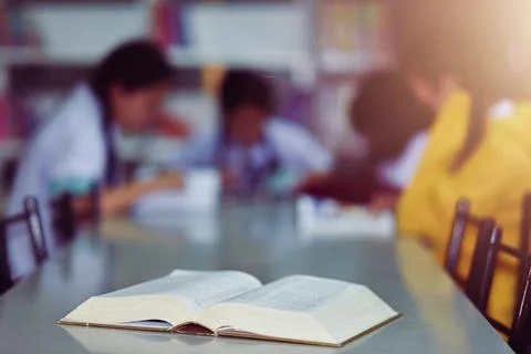 Open book on the table in library Stock Photos