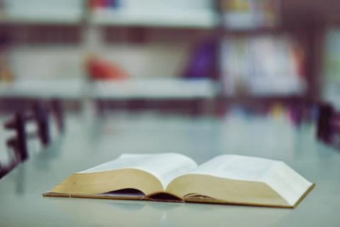 Open book on the table in library Stock Photos