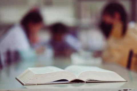 Open book on the table in library Stock Photos