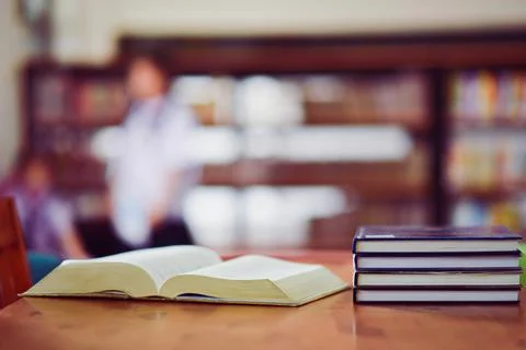 Open book on the table in library Stock Photos