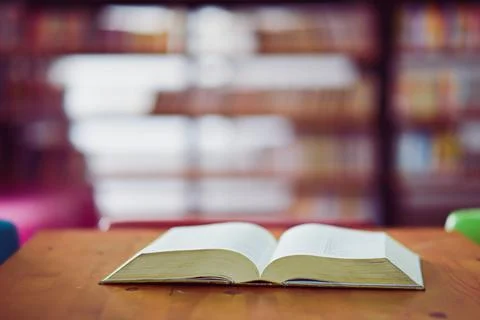 Open book on the table in library Stock Photos