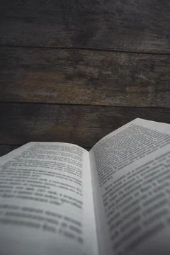 Open book with text against rustic wooden background Stock Photos