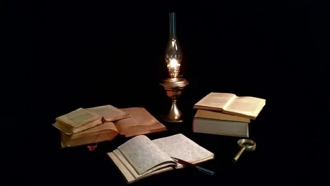 Open books and a handwritten notebook lie next to an old kerosene lamp. Stock Footage 141019616