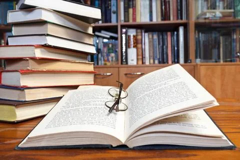 Open books on wooden table stack of books and open book and round glasses ... Stockfoto's