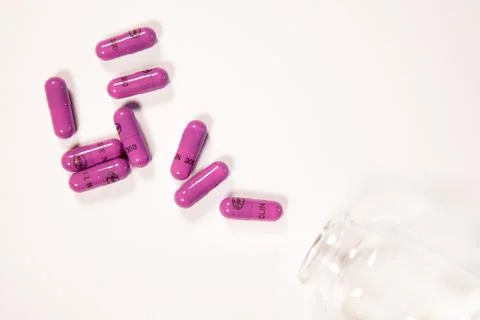 An open bottle of pink pills. Stock Photos