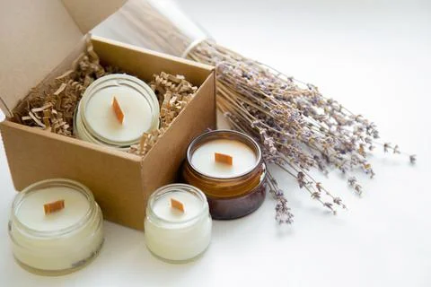 An open box with candles on a white background, next to it are several candles Stock Photos