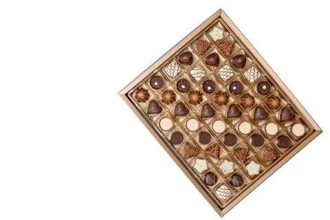 An open box of expensive chocolates on a white background Stock Photos