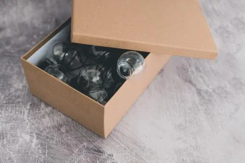 Open box with miniature lightbulb going out of it Stock Photos