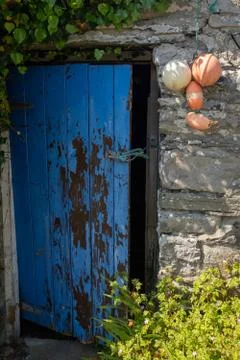 An open broken painted door held open with a piece of string of a traditional Stock Photos