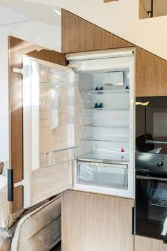 Open built-in refrigerator integrated under home staircase Fotos de archivo