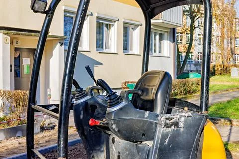 Open cabin of a small excavator with control levers in it. Stock Photos